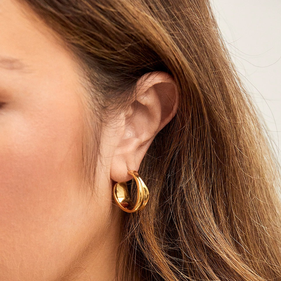 Introducing our Irregular Hoops.  These gold hoops are a staple to elevate your everyday look!  Material: Stainless Steel.